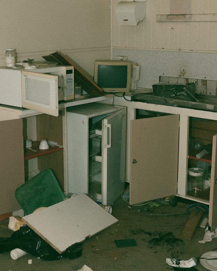 gallery-3 An abandoned kitchen featuring broken furniture and scattered debris, highlighting decay and neglect.